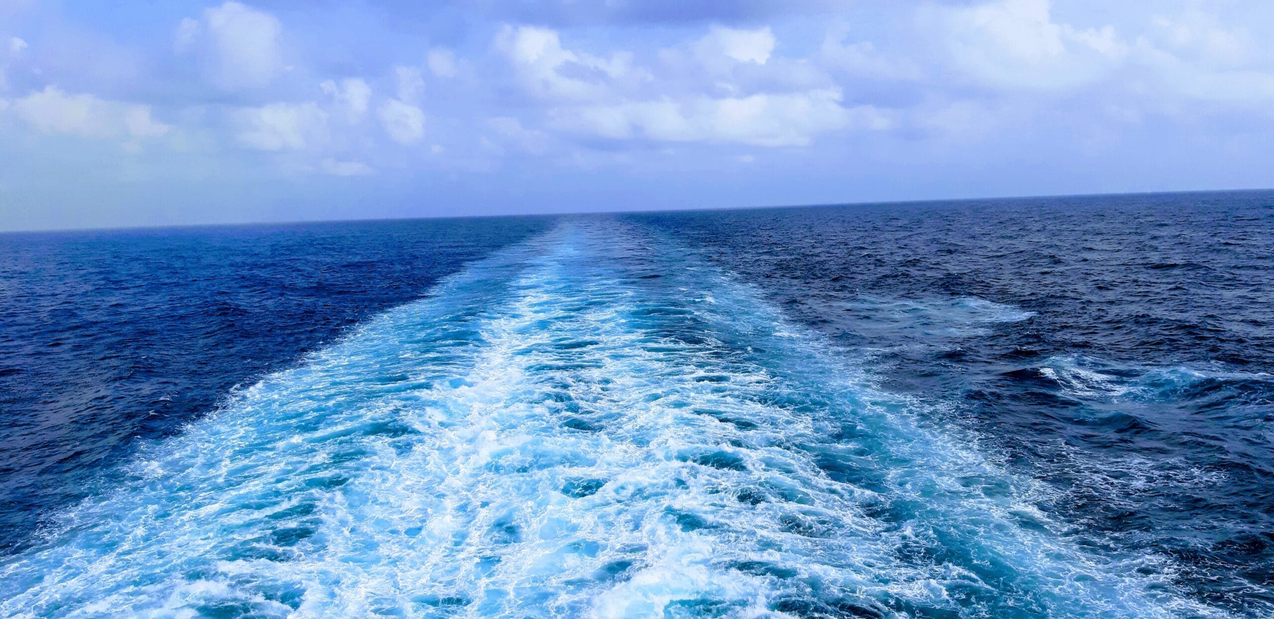 blue and white waves from back of cruise ship