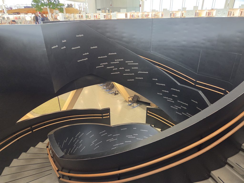 black stairway with Finnish words engraved on it creates an archtectural bridge